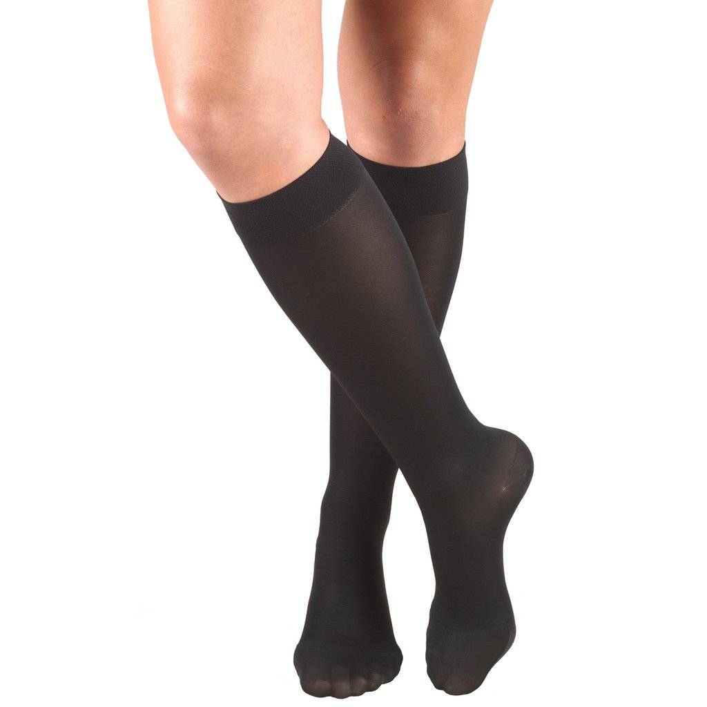 Black knee-high socks worn by a person on a white background