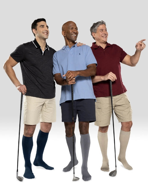 Three men standing together with golf clubs, wearing different colored shirts and shorts. Explore the Juzo Compressionsale collection of compression hosiery designed for comfort, support, and active everyday wear