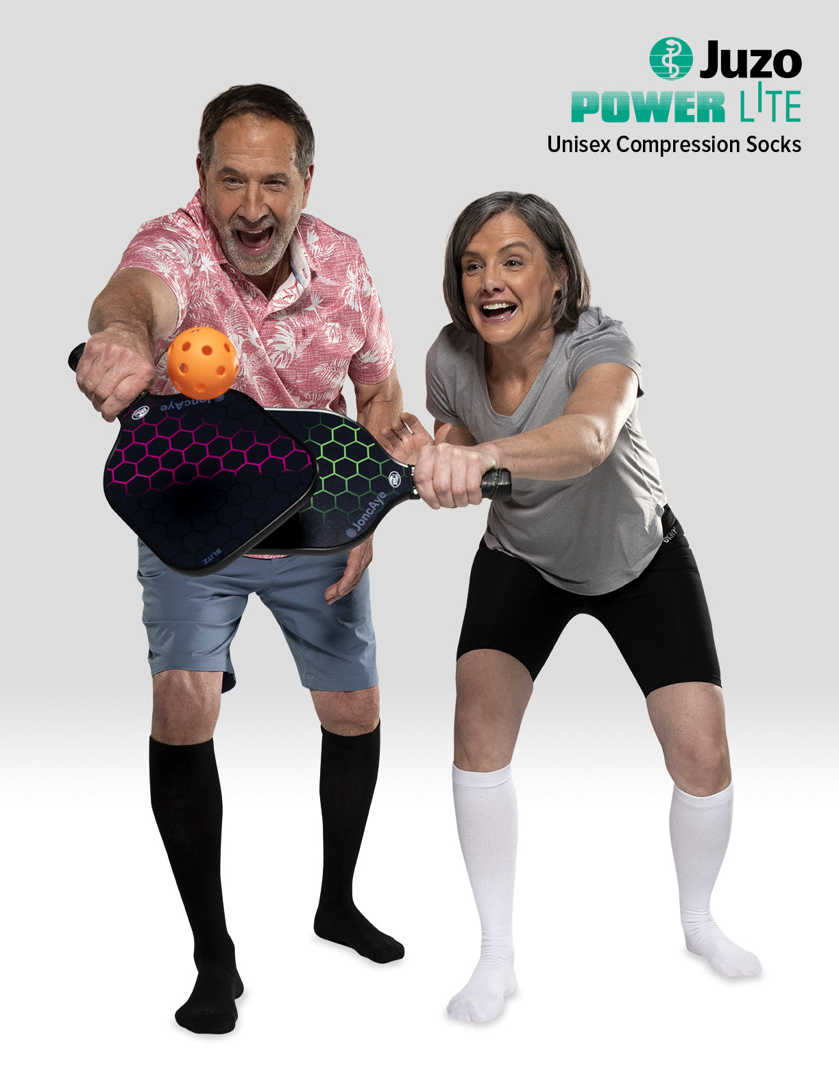 Two people playing pickleball with Juzo Power Lite compression socks displayed, featuring Compressionsale compression support for active lifestyles.
