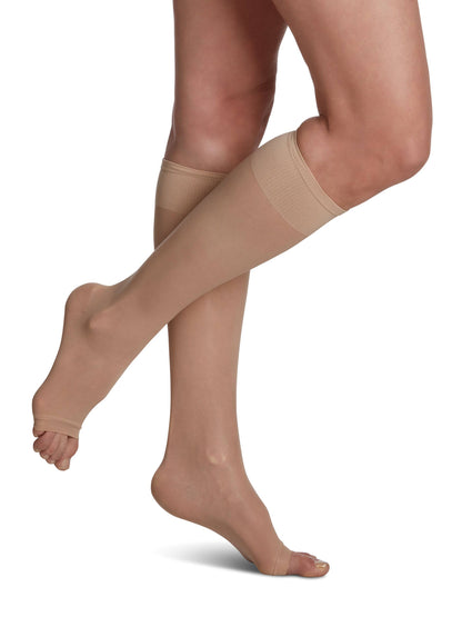 Beige knee-high socks worn by a person on a white background