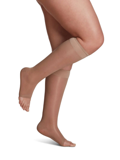 Beige knee-high socks worn by a person on a white background