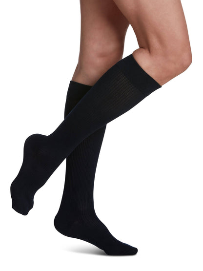 Navy knee-high socks worn by a person on a white background