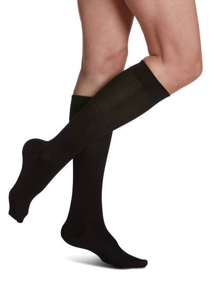 Navy knee-high socks worn by a person on a white background