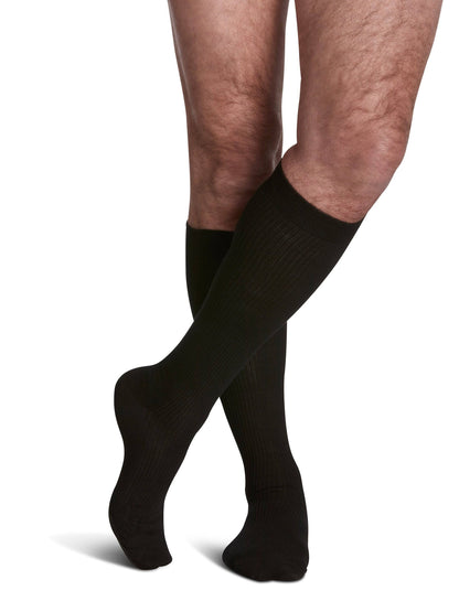 Black knee-high socks worn by a person on a white background