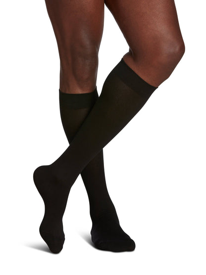 Black knee-high socks worn by a person on a white background