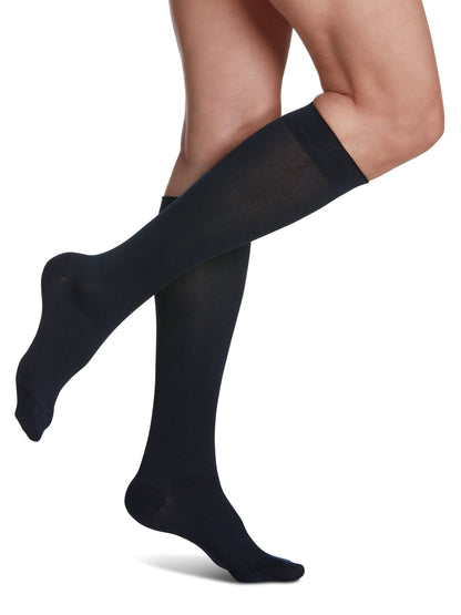Navy knee-high socks worn by a person on a white background