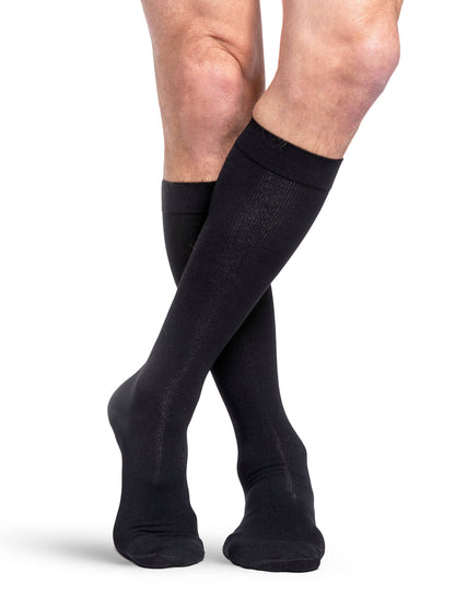 Black knee-high socks worn by a person on a white background