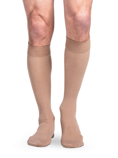 Beige knee-high socks worn by a person on a white background