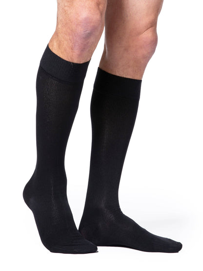 Black knee-high socks worn by a person on a white background