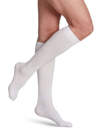 White knee-high socks worn by a person on a white background