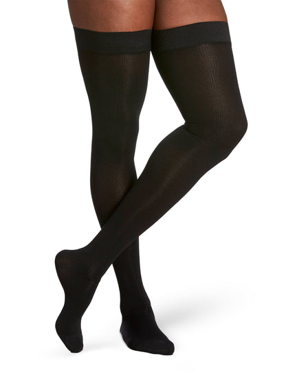 Black knee-high socks worn by a person on a white background