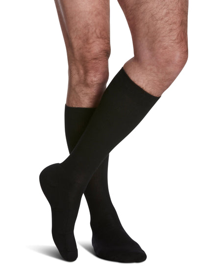 Black knee-high socks worn by a person on a white background