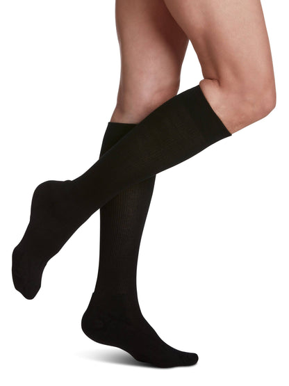 Black knee-high socks worn by a person on a white background