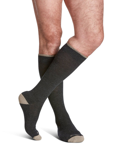 Dark gray knee-high socks with beige accents worn by a person on a white background
