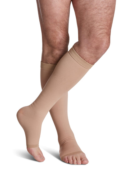 Beige compression stockings being worn on a white background