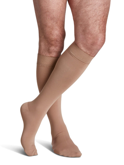 Beige compression stockings worn by a person on a white background