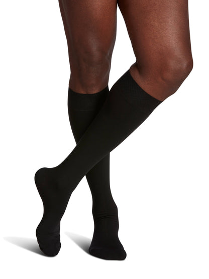 Black compression stockings worn by a person on a white background