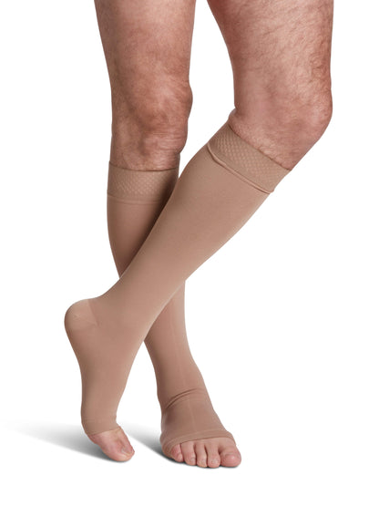 Beige compression stockings worn by a person on a white background