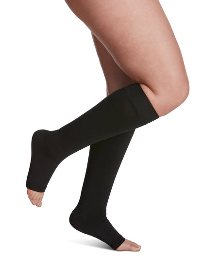 Black knee-high socks worn by a person on a white background