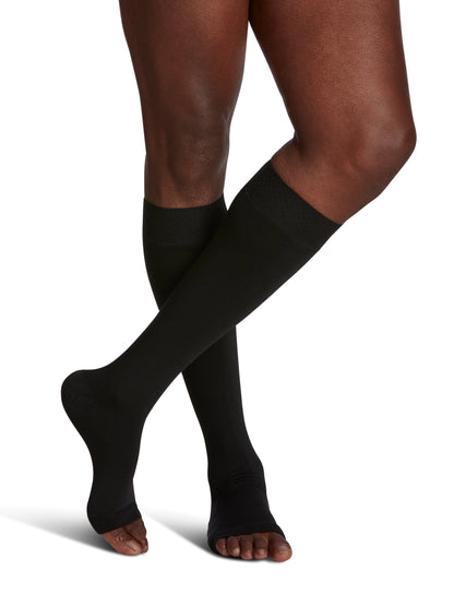 Black knee-high socks worn by a person on a white background