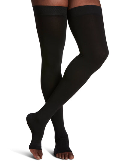 Black knee-high socks worn by a person on a white background