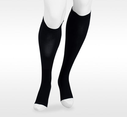 Black knee-high socks worn by a person on a white background. Explore the Juzo Compressionsale collection of compression hosiery designed for comfort, support, and everyday wear.