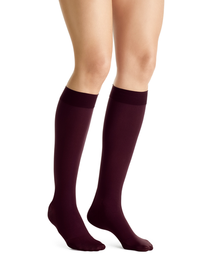Maroon knee-high socks worn by a person on a white background