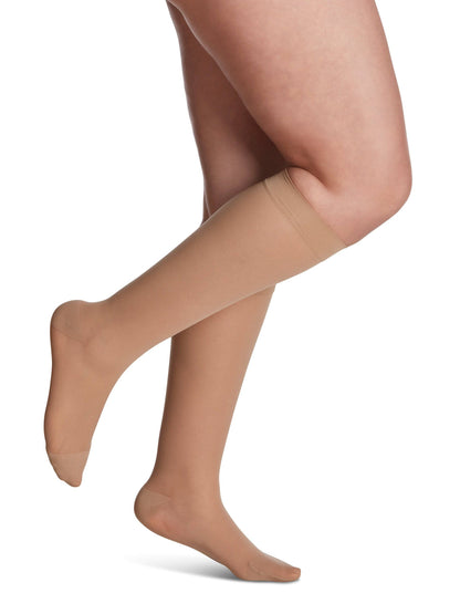 Golden knee-high socks worn by a person on a white background