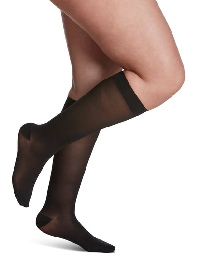 Black knee-high socks worn by a person on a white background
