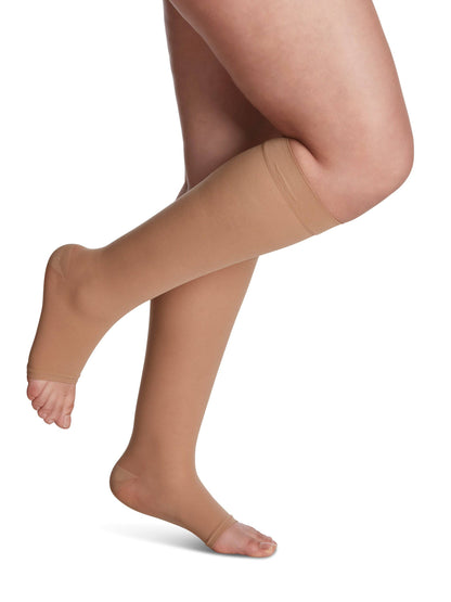 Golden compression stockings being worn on a white background