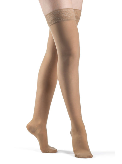 Golden sheer stockings with lace top on a white background