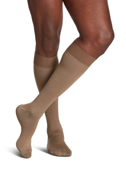 Beige knee-high socks worn by a person on a white background
