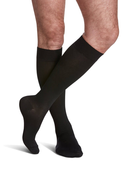 Black knee-high socks worn by a person on a white background