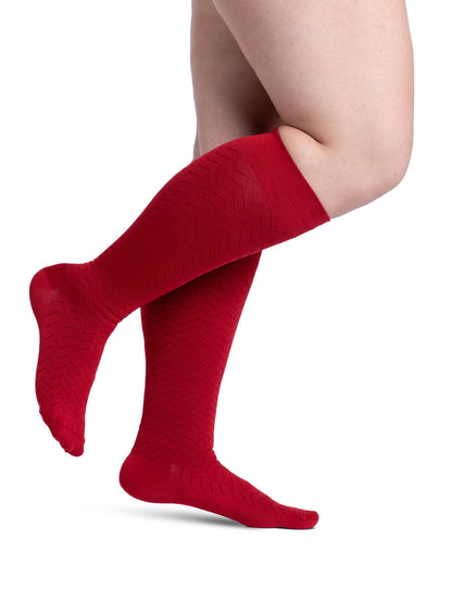 Red striped socks worn by a person on a white background