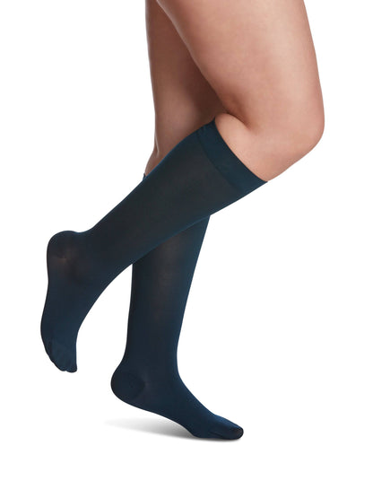 Navy blue knee-high socks worn by a person on a white background