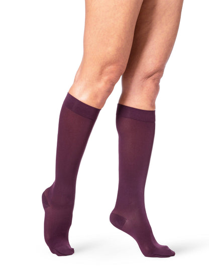 Black and Pink knee-high socks worn by a person on a white background