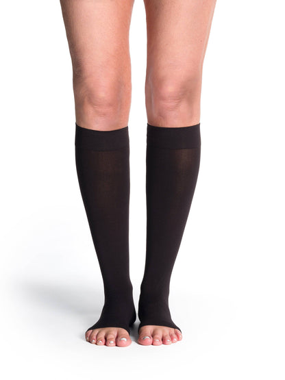 Black compression stockings worn by a person on a white background