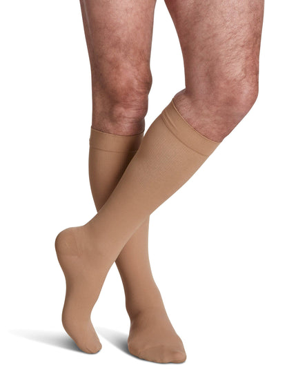 Brown compression stockings worn by a person on a white background