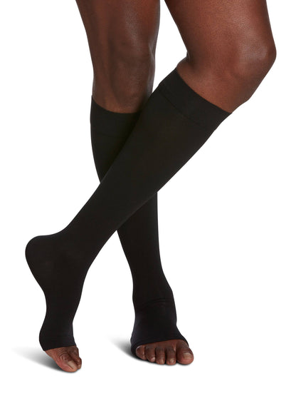 Black compression stockings being worn on a white background