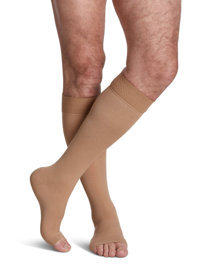 Beige compression stockings being worn on a white background