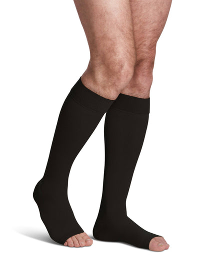 Black compression stockings being worn on a white background