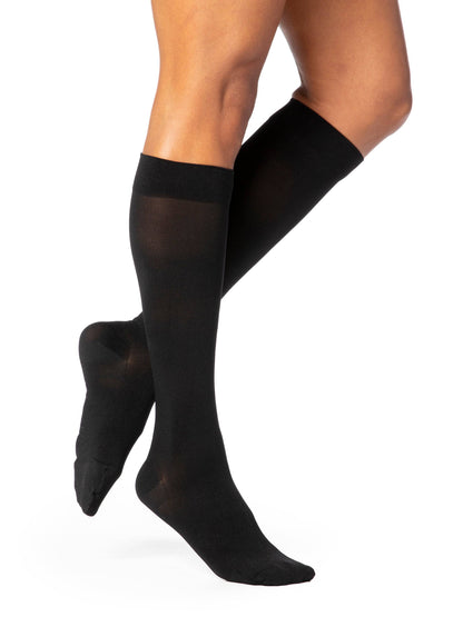Navy compression stockings being worn on a white background
