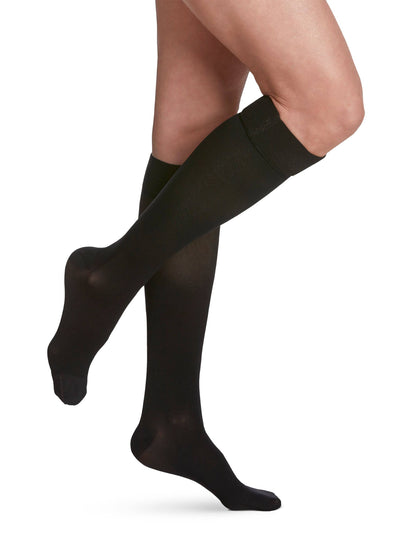 Black compression stockings worn by a person on a white background