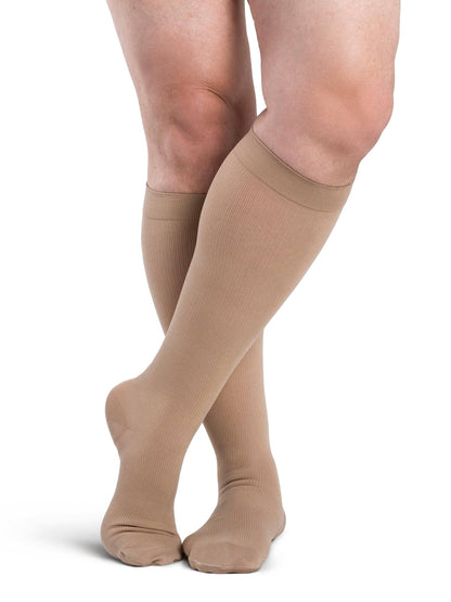 Beige knee-high socks worn by a person on a white background
