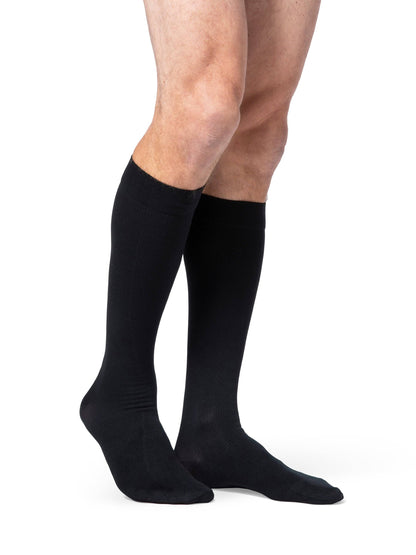 Black knee-high socks worn by a person on a white background