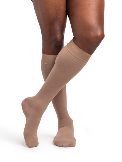 Beige knee-high socks worn by a person on a white background