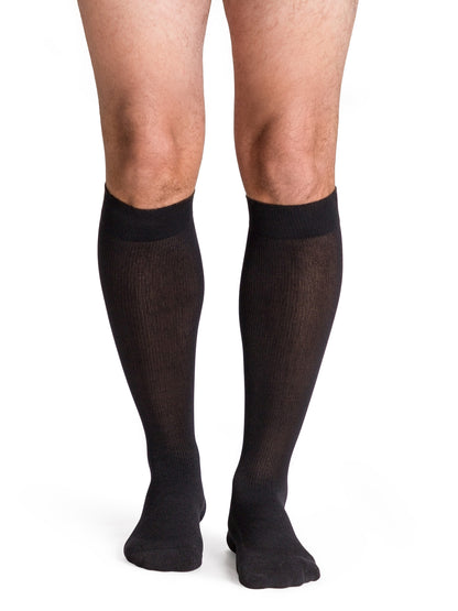 Black knee-high socks worn by a person on a white background