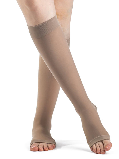 Beige compression stockings worn by a person on a white background