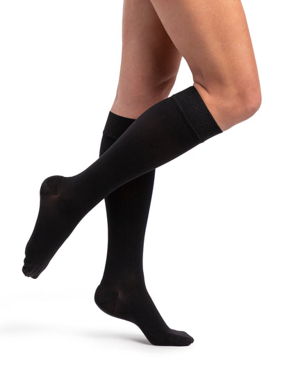 Black compression stockings worn by a person on a white background