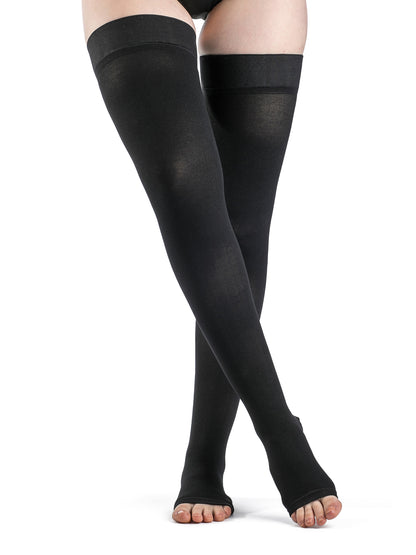Black compression stockings being worn on a white background